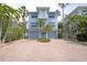 Lovely two-story home with three car garage and a paver driveway, accented by tropical palm trees at 2407 Avenue A, Bradenton Beach, FL 34217