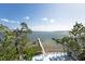 Scenic waterfront deck featuring comfortable seating, a wooden dock, and panoramic views of the bay at 2407 Avenue A, Bradenton Beach, FL 34217