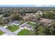 Overhead view of a single-story home with a well manicured lawn and driveway, nestled among mature trees in a neighborhood at 3266 Lanai Ave, North Port, FL 34288