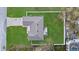 Birds eye view of the home showing the roof, driveway, fenced in backyard with patio set, and surrounding green lawn at 3266 Lanai Ave, North Port, FL 34288