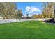Expansive, well-maintained lawn in the backyard, enclosed by a white fence, perfect for outdoor activities and privacy at 3266 Lanai Ave, North Port, FL 34288