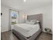 Comfortable bedroom with a tufted headboard, plush pillows, and a view to the outdoors at 3266 Lanai Ave, North Port, FL 34288