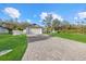 Wide paver driveway leading to a two car garage, complemented by lush lawn and exterior home details at 3266 Lanai Ave, North Port, FL 34288