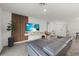 Modern living room with sleek flooring, a stylish sofa, a mounted TV, and a decorative wood panel at 3266 Lanai Ave, North Port, FL 34288