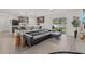 Open-concept living area with bar seating, sleek flooring, a modern sofa, and a view of the backyard at 3266 Lanai Ave, North Port, FL 34288