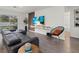 Modern living room with sleek flooring, a stylish sofa, a mounted TV, and sliding glass doors at 3266 Lanai Ave, North Port, FL 34288