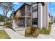 Two-story condo building with screened patios, light-colored facade, and wood stairway at 3758 59Th W Ave # 4099, Bradenton, FL 34210