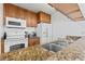The kitchen features wood cabinets, granite countertops, and white appliances at 3758 59Th W Ave # 4099, Bradenton, FL 34210
