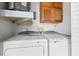 A laundry room featuring a modern washer and dryer with overhead storage cabinets at 3758 59Th W Ave # 4099, Bradenton, FL 34210