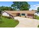 Aerial view of a charming home with a brick facade, lovely landscaping, and a large driveway at 3802 24Th W Ave, Bradenton, FL 34205