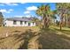 Secluded backyard retreat with a lush lawn and mature trees surrounding a modern one-story home at 3807 Las Vegas Ave, North Port, FL 34288