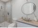 Contemporary bathroom featuring modern vanity and toilet, plus tiled shower and round mirror at 3916 N Shell Rd, Sarasota, FL 34242