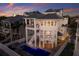 Stunning multi-story home with a pool, balconies, outdoor fireplace, and modern architectural design at sunset at 3916 N Shell Rd, Sarasota, FL 34242