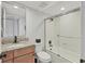 Bright bathroom featuring a granite vanity top, framed mirror, and a shower with glass doors at 404 Cerromar N Cir # 119, Venice, FL 34293