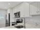 Bright kitchen with stainless steel appliances, white cabinets, and a marble countertop at 404 Cerromar N Cir # 119, Venice, FL 34293