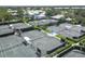 Aerial view of multiple tennis courts with shelters in a meticulously landscaped community at 404 Cerromar N Cir # 119, Venice, FL 34293