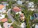 Stunning aerial view of a home with a red tile roof, pool and lush landscaping, showcasing its prime location at 4129 Roberts Point Cir, Sarasota, FL 34242