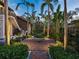 Serene backyard features a meticulously designed garden with brick pathways, lush greenery, and ambient lighting at 4129 Roberts Point Cir, Sarasota, FL 34242