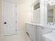 Bathroom with white cabinetry, dual sinks, and elegant finishes with classic tile at 4129 Roberts Point Cir, Sarasota, FL 34242
