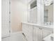 Well-lit bathroom boasts double sinks, white cabinetry, and stylish tiled floors at 4129 Roberts Point Cir, Sarasota, FL 34242