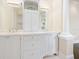 Elegant bathroom with dual sinks, custom white cabinetry, and classic fixtures at 4129 Roberts Point Cir, Sarasota, FL 34242