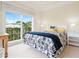 Comfortable bedroom with a large window overlooking a balcony, patterned bedding, and neutral color scheme at 4129 Roberts Point Cir, Sarasota, FL 34242