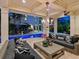 Covered patio boasts comfortable seating, a large chandelier, and views of the pool and lush surroundings at 4129 Roberts Point Cir, Sarasota, FL 34242