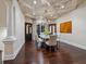 Elegant dining room features dark wood floors and a coffered ceiling with an ornate chandelier at 4129 Roberts Point Cir, Sarasota, FL 34242
