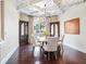 Elegant dining room featuring a coffered ceiling, hardwood floors, and a stylish chandelier at 4129 Roberts Point Cir, Sarasota, FL 34242