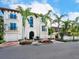 Elegant two-story home with lush landscaping, a fountain, and a paver driveway at 4129 Roberts Point Cir, Sarasota, FL 34242