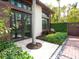 Exterior featuring a charming courtyard entrance, lush landscaping, and elegant architectural details at 4129 Roberts Point Cir, Sarasota, FL 34242