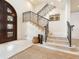 Inviting foyer features a staircase with iron railing, a statement front door, and neutral decor at 4129 Roberts Point Cir, Sarasota, FL 34242
