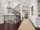 Grand foyer with dark wood floors, a wrought iron staircase, and a decorative chandelier at 4129 Roberts Point Cir, Sarasota, FL 34242