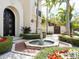 Elegant front entrance featuring a fountain, lush greenery, and a tropical landscape at 4129 Roberts Point Cir, Sarasota, FL 34242