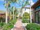 Pathway lined with tropical plants and flowers leading to a beautiful home, offering a picturesque entrance at 4129 Roberts Point Cir, Sarasota, FL 34242