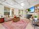 Cozy living room with whitewashed ceiling, plush seating, and a view of the lush backyard at 4129 Roberts Point Cir, Sarasota, FL 34242