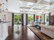 Open-concept living area with hardwood floors, stylish seating, and large windows overlooking the outdoor area at 4129 Roberts Point Cir, Sarasota, FL 34242
