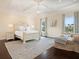 Spacious bedroom featuring a tray ceiling, large windows, and a cozy sitting area at 4129 Roberts Point Cir, Sarasota, FL 34242