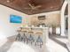 Outdoor kitchen and entertainment area with a bar, stainless steel appliances, and ceiling fan at 4129 Roberts Point Cir, Sarasota, FL 34242