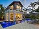 Beautiful pool area with covered outdoor lounge, fireplace, and outdoor seating surrounded by lush landscaping at 4129 Roberts Point Cir, Sarasota, FL 34242