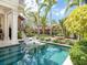 Tranquil swimming pool with in-pool lounge chairs and lush landscaping creates a relaxing backyard oasis at 4129 Roberts Point Cir, Sarasota, FL 34242