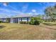 View of a light-colored home with an enclosed lanai, manicured shrubs, and a spacious lawn at 4220 Center Pointe Ln # 21, Sarasota, FL 34233