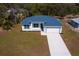 An aerial view of a modern, single-story home with a metal roof, long driveway, and well-maintained landscaping at 4240 Adelaide Ave, North Port, FL 34288