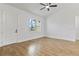 Bedroom with wood-look tile flooring, white walls, large window, and ceiling fan at 4240 Adelaide Ave, North Port, FL 34288