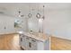 Island with granite countertops, white cabinets, and modern pendant lighting at 4240 Adelaide Ave, North Port, FL 34288