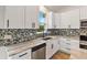 Close-up of a modern kitchen featuring white cabinets, stainless steel appliances, and a colorful tiled backsplash at 4240 Adelaide Ave, North Port, FL 34288