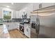 Kitchen with stainless steel appliances, white cabinets, stylish backsplash, and wood-look tile flooring at 4240 Adelaide Ave, North Port, FL 34288