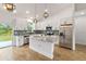 Bright, open kitchen featuring white cabinets, stainless steel appliances, granite countertops and a center island at 4240 Adelaide Ave, North Port, FL 34288