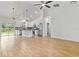 Open-concept living space featuring kitchen, dining area, and living room with wood-look tile flooring at 4240 Adelaide Ave, North Port, FL 34288