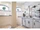 The main bathroom has many mirrors, neutral tile, and an abundance of natural light at 4386 Library St, Port Charlotte, FL 33948